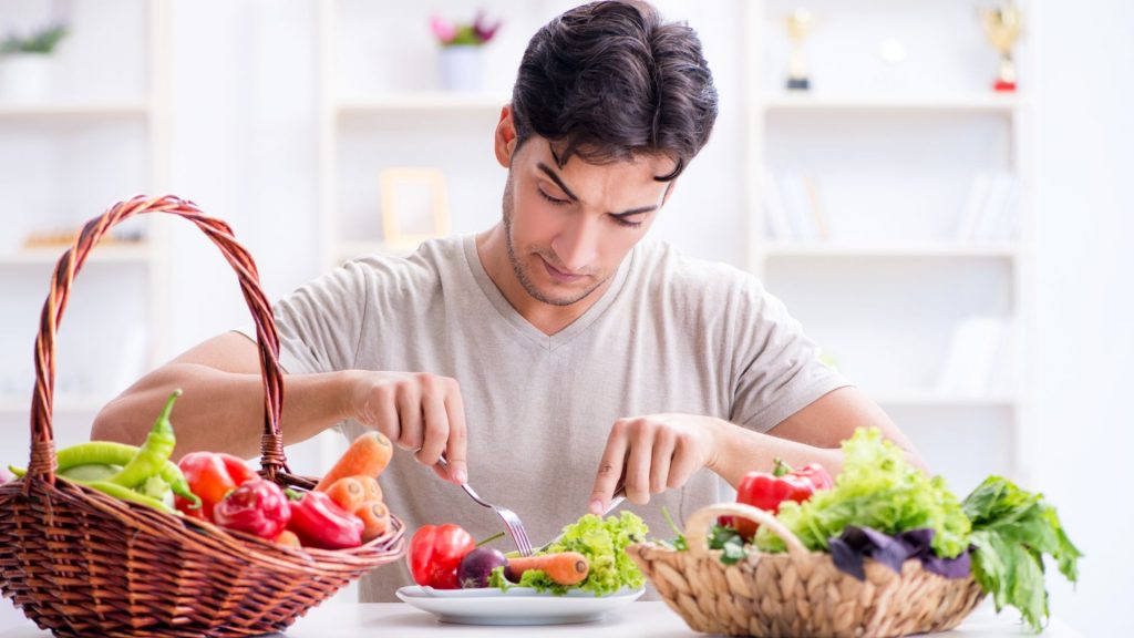 Mężczyzna spożywa posiłek, który zaleca dieta na obniżenie hemoglobiny glikowanej.
